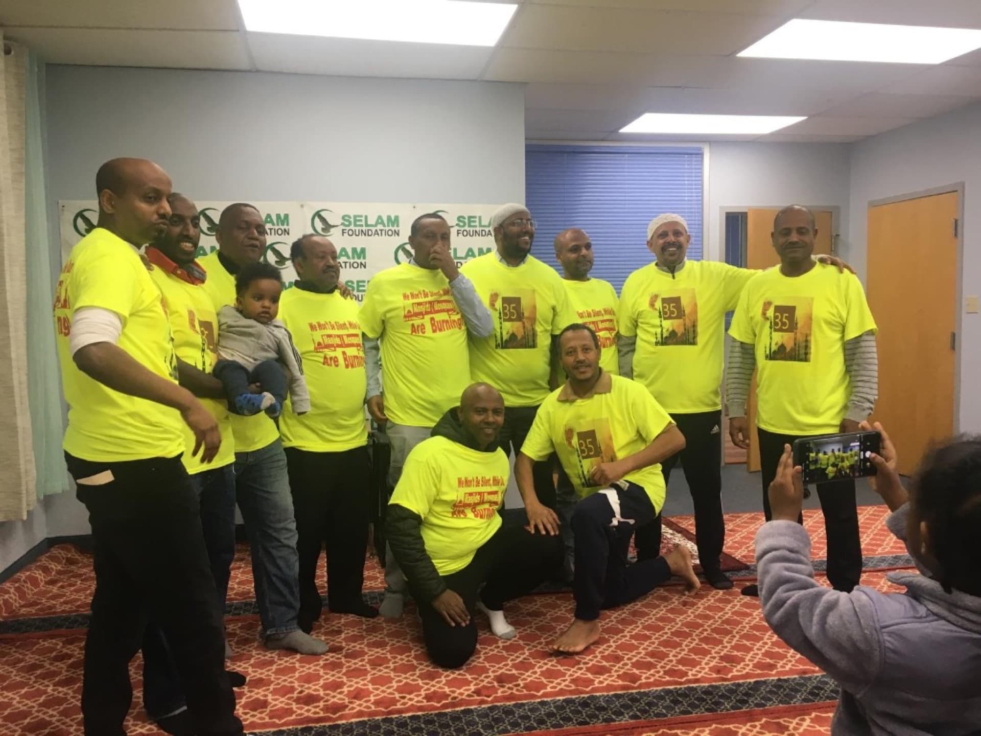 Community members gathered in front of a Selam Foundation banner at an indoor program