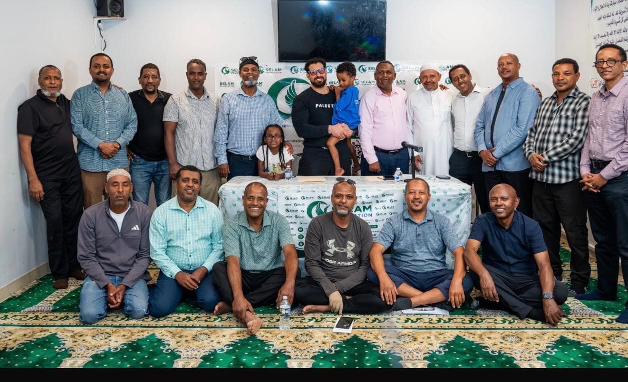 Selam Foundation community members gather for a group photo in front of the foundation banner