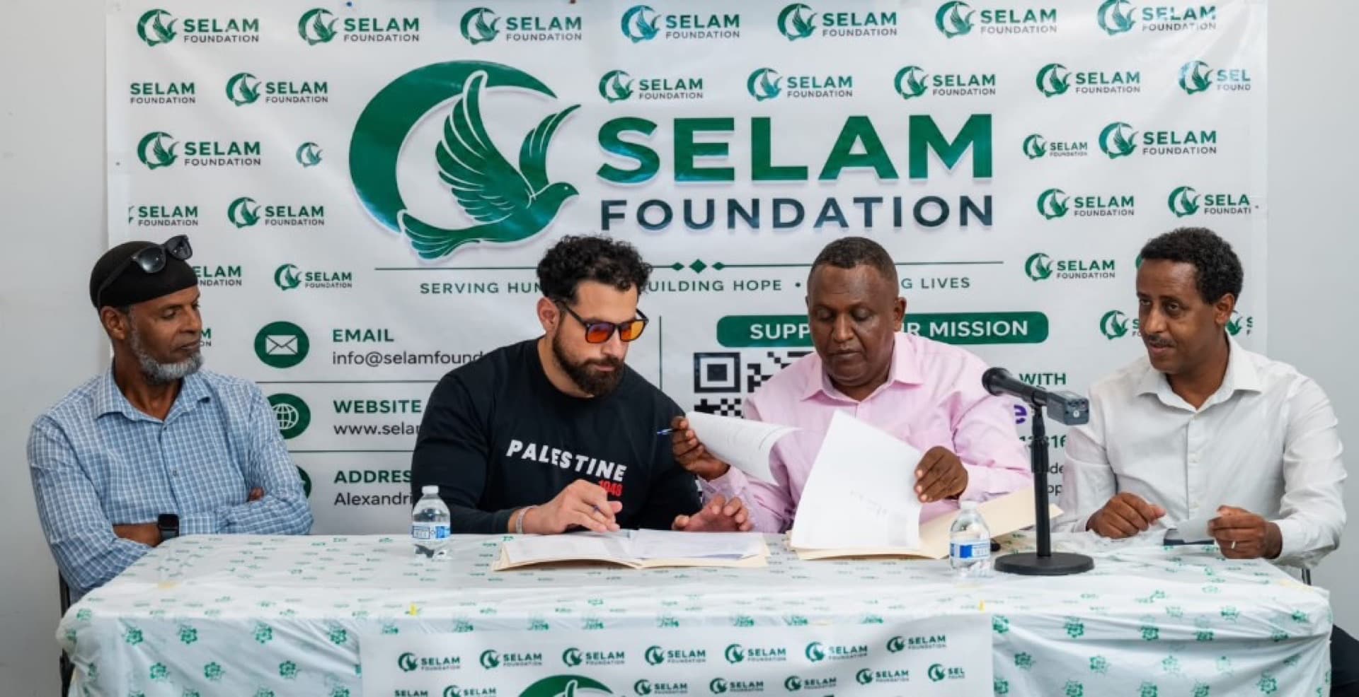 Community leaders seated at a Selam Foundation table during a formal signing ceremony