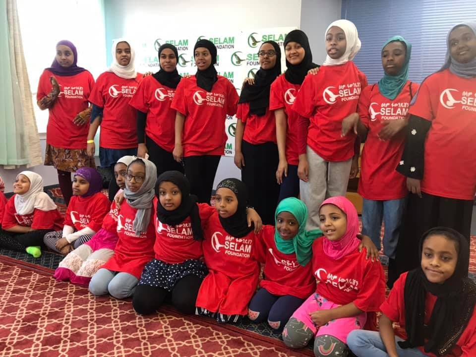 Young sisters in Selam Foundation shirts gathered for a Qur’an and youth program